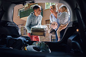 Happy Couple With a Child Packing the Car for a Holiday Trip