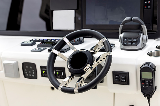 Steering wheel and control panel on luxury yacht, background with copy space, full frame horizontal composition