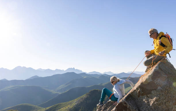 istock Mature couple climb to mountain summit 1603931519