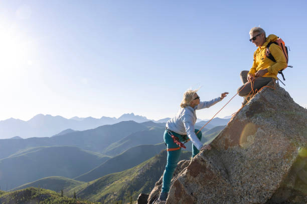 istock Mature couple climb to mountain summit 1603932076