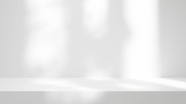 istock white table background podium stage for text design and products, white stage with sunlight and shadow, white wall and table background 1603947432
