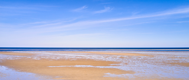 maritime seaside landscape with water, sand bank and white cloud, garonne estuary near Royan, France