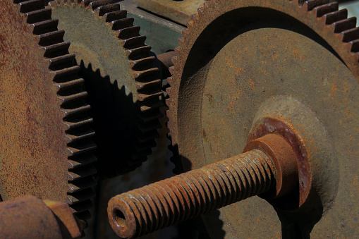 close up of rusted, weathered, gear wheels, originally used to power agricultural machinery, for sale as decoration at a salvage yard, Long Island, New York