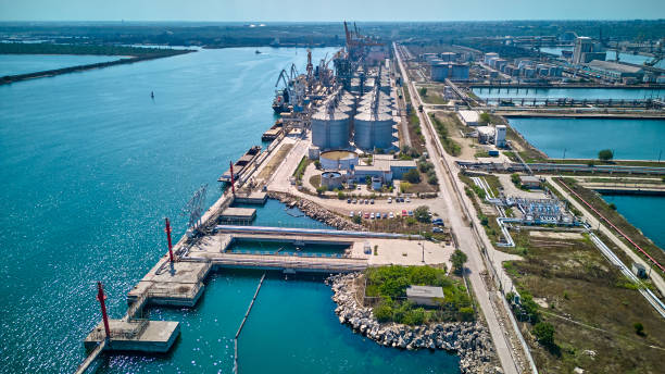istock Loading grain into holds of sea cargo vessel in seaport from silos of grain storage. Bunkering of dry cargo ship with grain. Aerial top view 1604013111