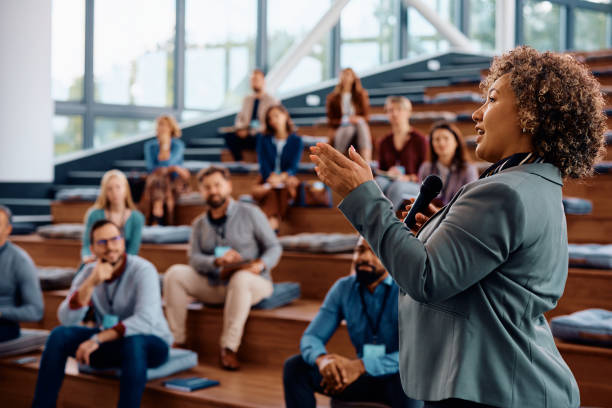 Female speaker talking on a business conference at convention center.