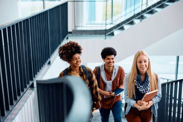 istock Multiracial group of happy college students in a hallway. 1604038142