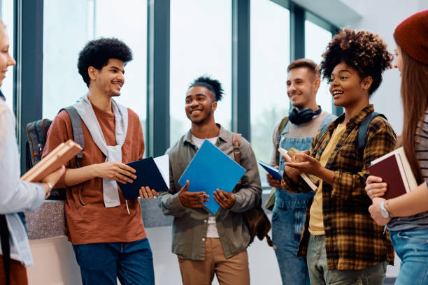 istock Happy students communicating after a lecture in hallway at the university. 1604038647