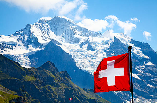 istock Swiss flag atop a mountain with grass and snow 160406799