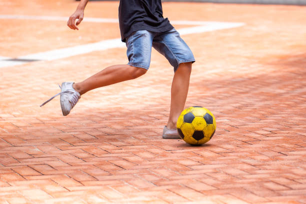 futsal-spieler kontrollieren den ball für den schuss aufs tor. gelber ball. - soccer field soccer single line field stock-fotos und bilder