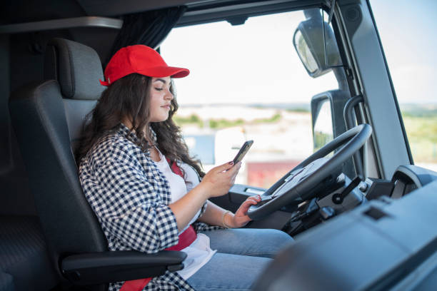 istock Female truck driver relaxing and using phone. 1604175359