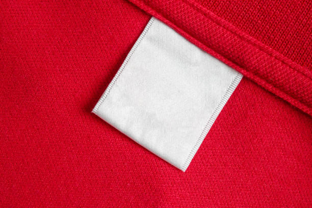 Blank white laundry care clothes label on red shirt fabric texture background