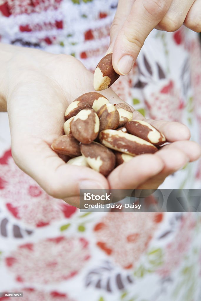 Woman Eating Handful Of Brazil Nuts Healthy alternative snack Brazil Nut Stock Photo