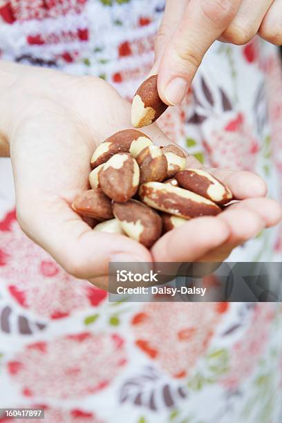 Woman Eating Handful Of Brazil Nuts Stock Photo - Download Image Now - Brazil Nut, Adult, Adults Only
