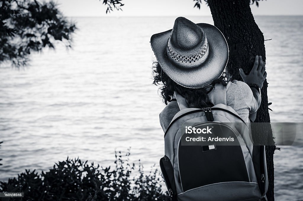 Jeune fille en regardant la mer et l'horizon, derrière un arbre - Photo de Adulte libre de droits