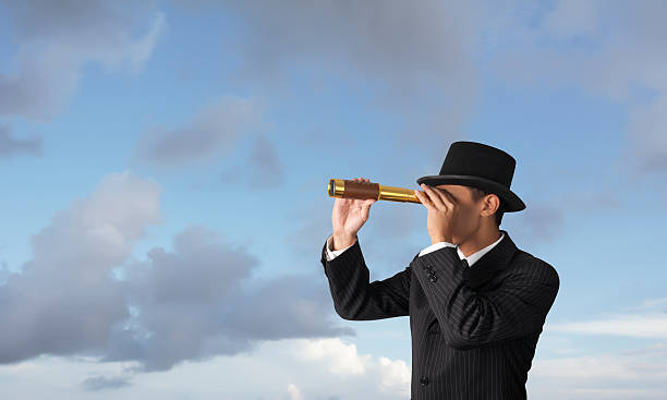 istock business man looks through a telescope 160419270