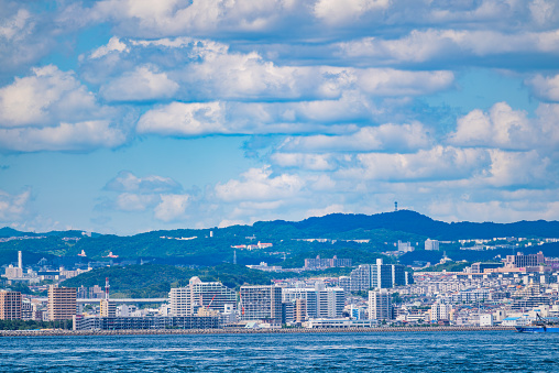 The cityscape of Kobe seen from Awaji Island in Japan is a breathtaking sight. The weather is perfect, with a clear blue sky adorned by white clouds, and simply gazing at it makes you forget all the stresses of daily life.