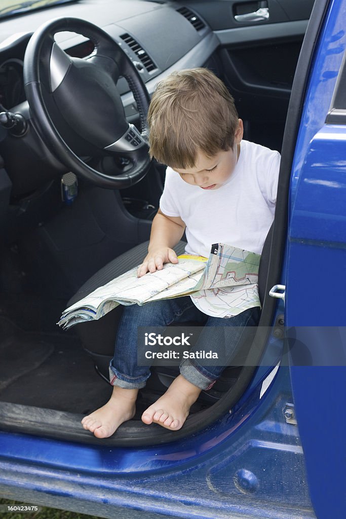 Boy with road map sits in car Boy with road map sits in blue car Road Map Stock Photo