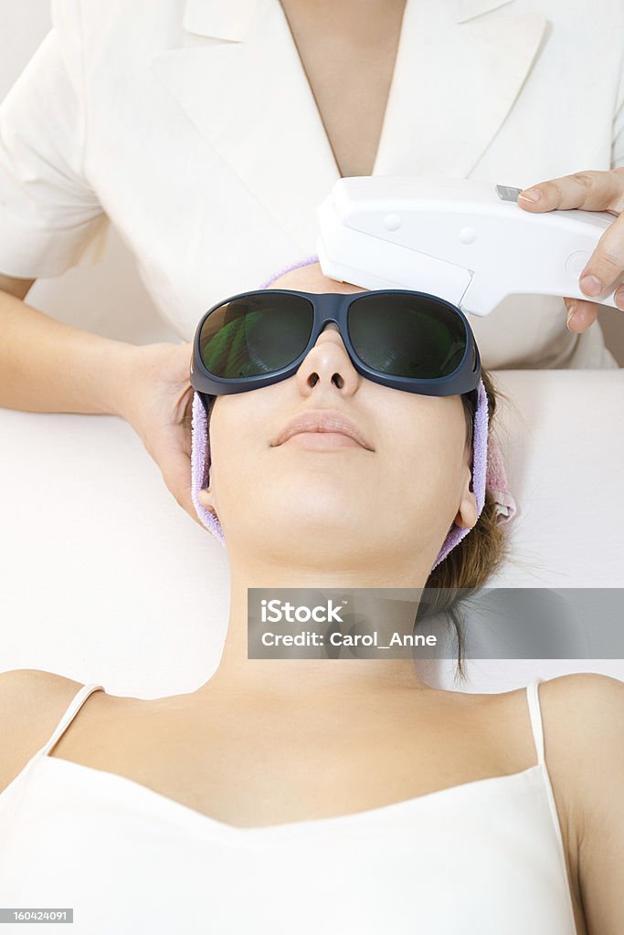 Giovane donna ricevendo terapia al laser - Foto stock royalty-free di Accudire