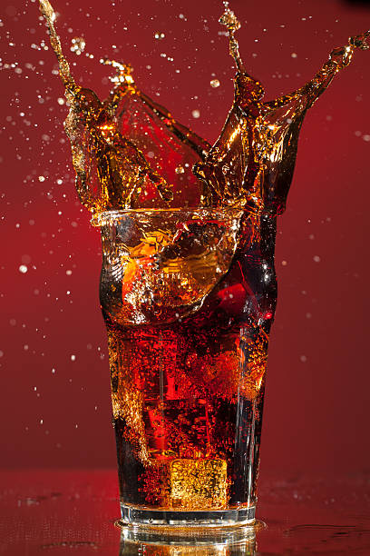 Cerveza de Cola con salpicaduras de cubo de hielo - foto de stock