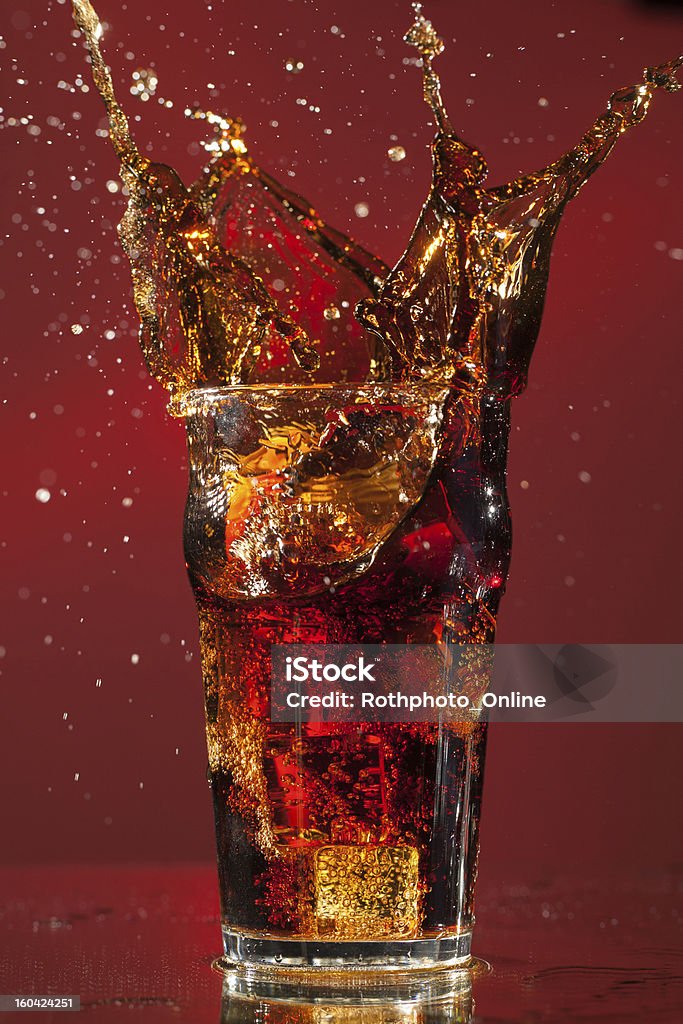 Pinta di Cola con splash cubo di ghiaccio - Foto stock royalty-free di Bibita gassata