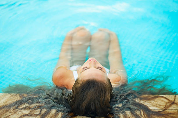 istock Woman relaxing in pool. Rear view 160424970