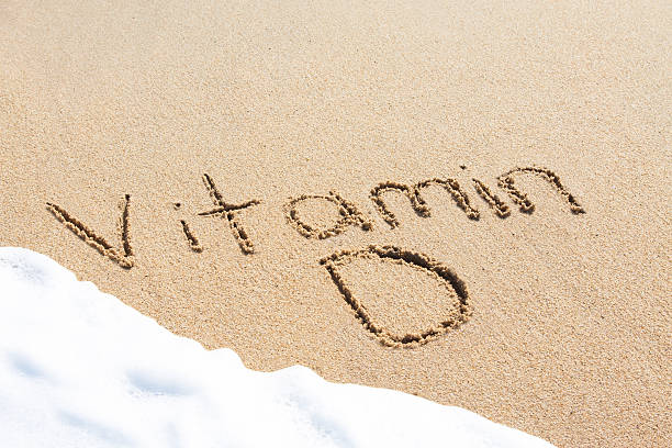 vitamina d por escrito en la arena - vitamin d fotografías e imágenes de stock