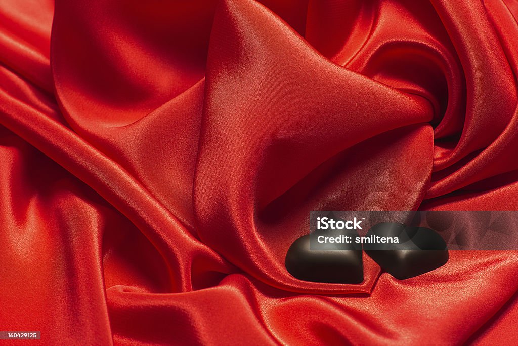 Nero cioccolato su seta rossa - Foto stock royalty-free di Amore