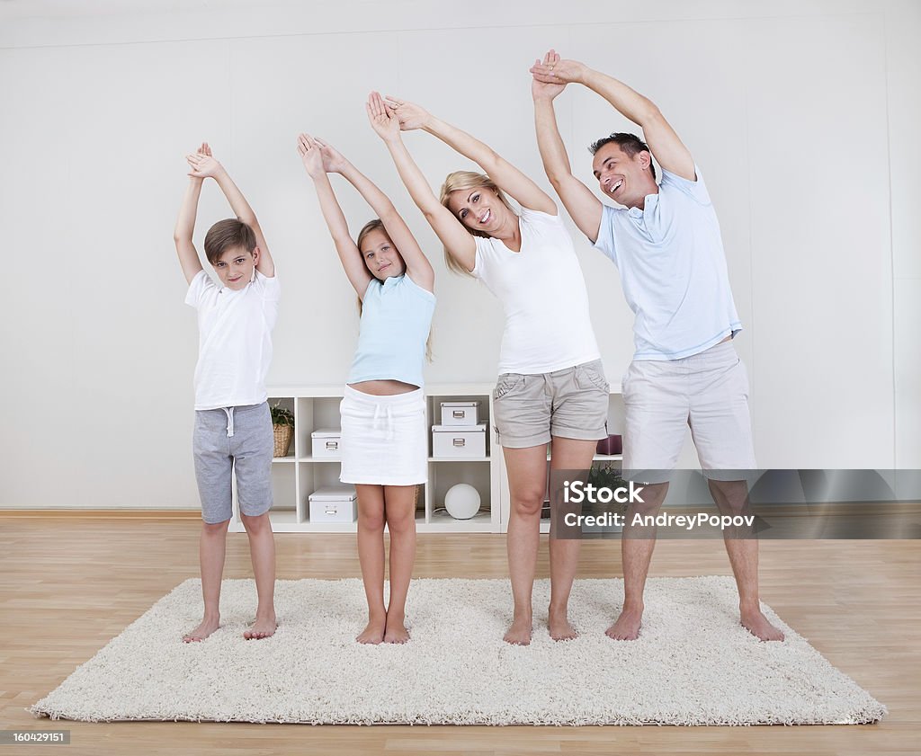Семья делает растяжения упражнения на Ковер - Стоковые фото Мать роялти-фри