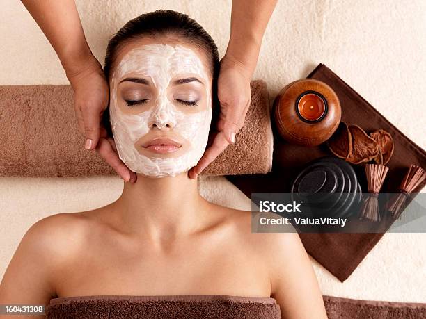 Spa Massage For Woman With Facial Mask On Face Stock Photo - Download Image Now - Adult, Alternative Therapy, Applying