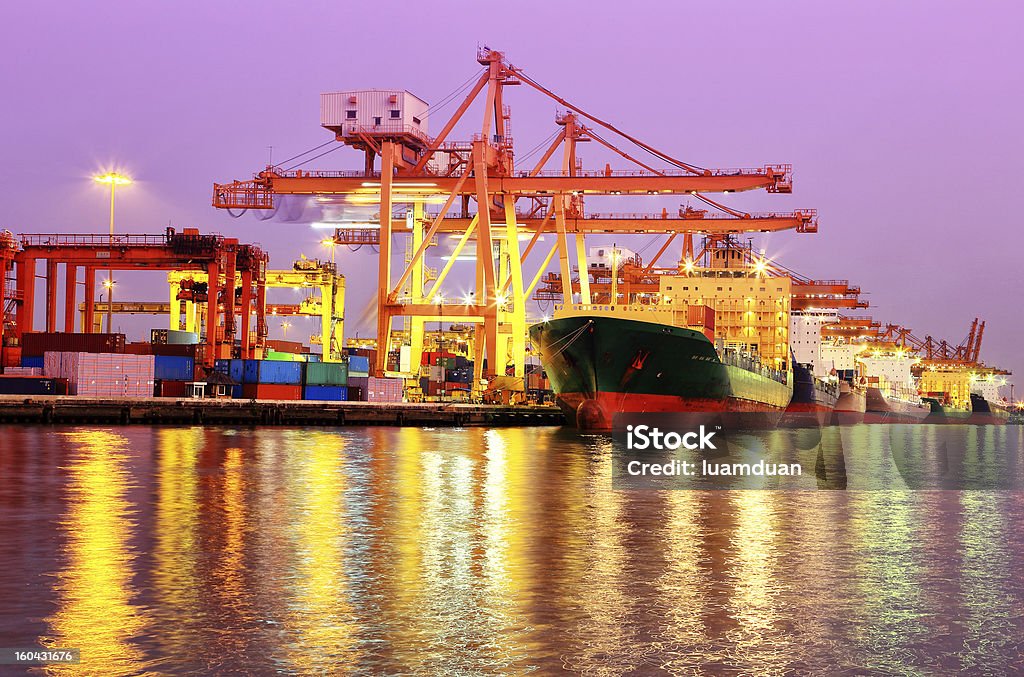 Container Cargo freight ship Industrial Container Cargo freight ship with working crane bridge in shipyard at dusk for Logistic Import Export background Bangkok Stock Photo