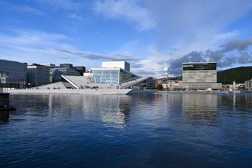 Oslo, Norway, July 6, 2023 - The Oslo Opera House (Norwegian: Operahuset), with the Edvard Munch Museum in the background.