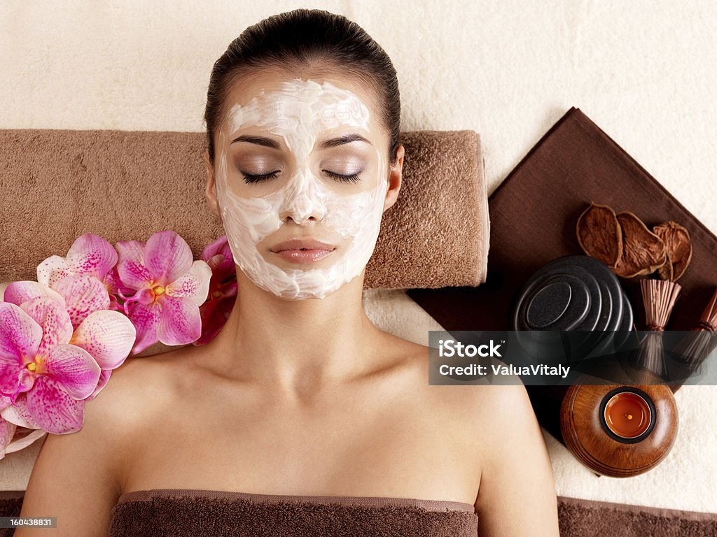 woman relaxing with cosmetic mask on face Young woman relaxing with cosmetic mask on face at beauty salon- indoors Adult Stock Photo