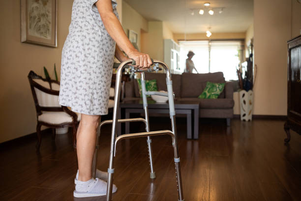 istock Elderly woman with a disability and a walker exercising 1604389424