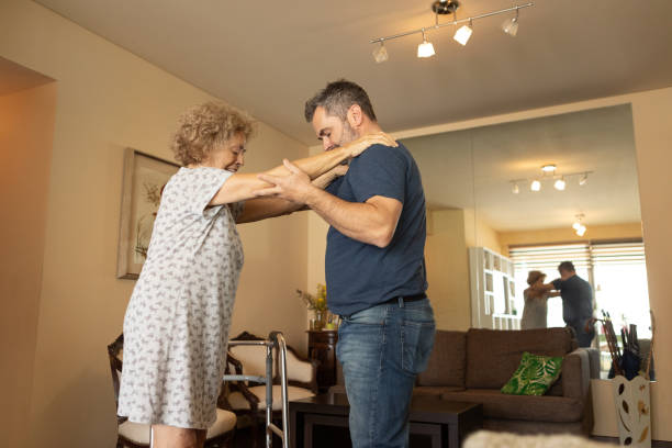 istock Elderly woman with a disability and a walker exercising with a physiotherapist 1604389425