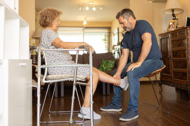 istock Elderly woman with a disability and a walker exercising with a physiotherapist 1604389426