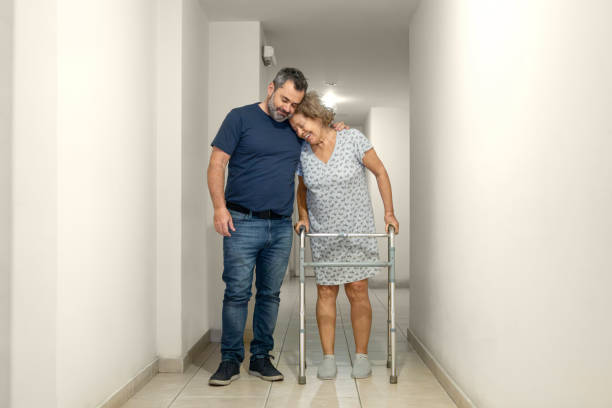 Elderly woman with a disability and a walker assisted by a physiotherapist in the hospital Elderly woman with a disability and a walker assisted by a physiotherapist in the hospital - Buenos Aires - Argentina hip replacement stock pictures, royalty-free photos & images