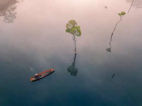 Drone view fisherman in Tuyen Lam lake in a foggy morning, Da Lat city, Lam Dong province, central high lands Vietnam