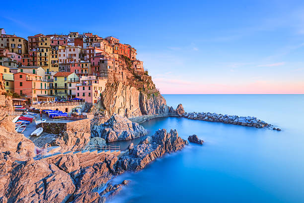 villaggio di manarola, rocce e mare al tramonto. cinque terre, italia - manarola foto e immagini stock