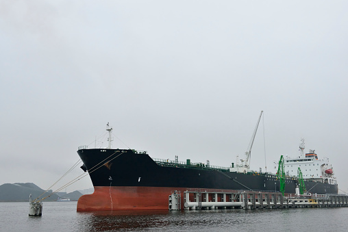 Belfast, Northern Ireland, United Kingdom - September 27, 2020: Cargo ship being loaded with the crushed remains of cars crushed at a car recycling plant located within Belfast Port.