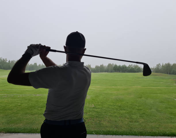 istock Back of golf player in white shirt waving golf 1604529104