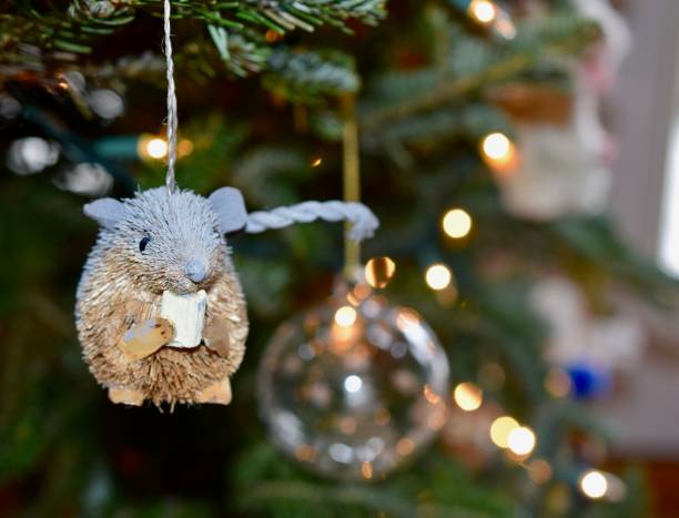 istock Christmas tree branch adorned with a cute  mouse ornament and white string lights 1604542923