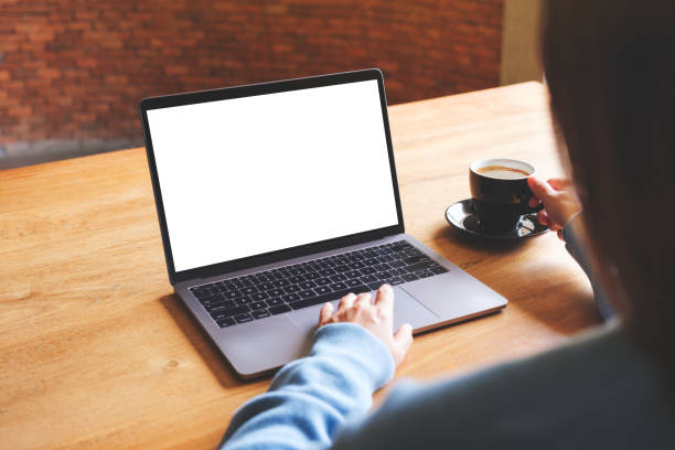 istock Mockup image of a woman using and working on laptop computer with blank white desktop screen while drinking coffee 1604575044