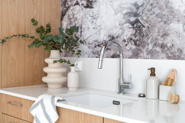 istock modern chrome faucet over basin and wooden dish brushes with detergent 1604590584