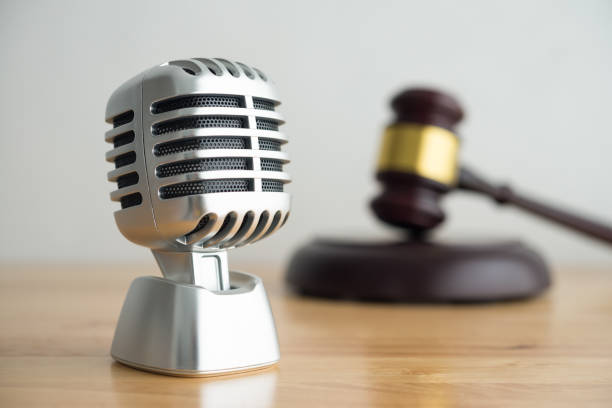 istock Retro microphone with hammer judge gavel on wooden table and white wall background copy space. 1604624817