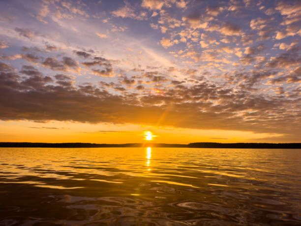 istock Water surface. View of a Sunset sky background. Dramatic gold sunset sky with evening sky clouds over the sea. View of a Crystal clear sea water texture. Landscape. Small waves. Water reflection 1604636556