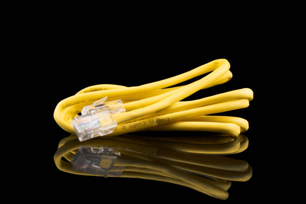 internet data cable isolated on black background. internet communication concept. network internet yellow cable isolated over black with clipping path. ethernet cable. network cable - data technology computer cable power line imagens e fotografias de stock