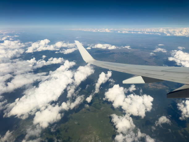 istock White wing from airplane window with mountain range below on sunny day. Great views of desert landscape and snowed peaks from plane 1604647932