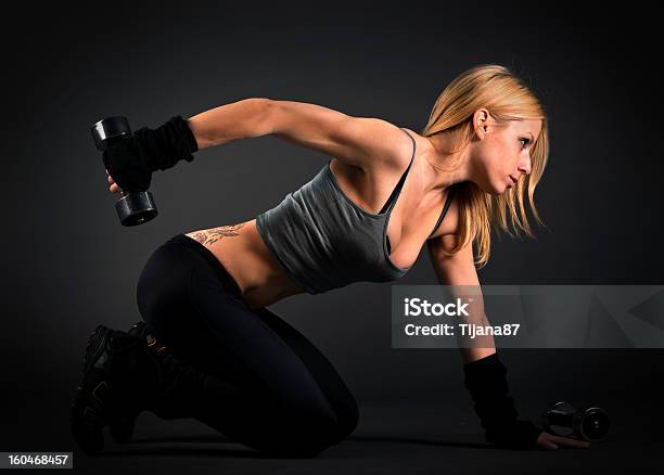 Fit Woman Exercising With Weights Over A Dark Background Stock Photo - Download Image Now