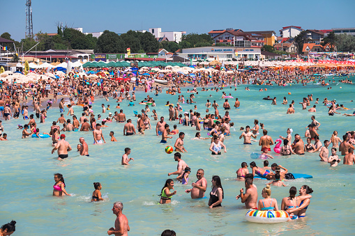 Lots of people in the sea and on the beach. Many tourists on vacation.Romania, Costinesti. July, 21, 2023Many tourists on vacation.Romania, Costinesti. July, 21, 2023