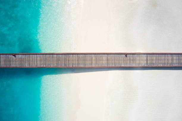top view jetty over sandy beach and lagoon amazing aerial view wooden jetty over wide sandy beach and tropical lagoon jetty aerial stock pictures, royalty-free photos & images